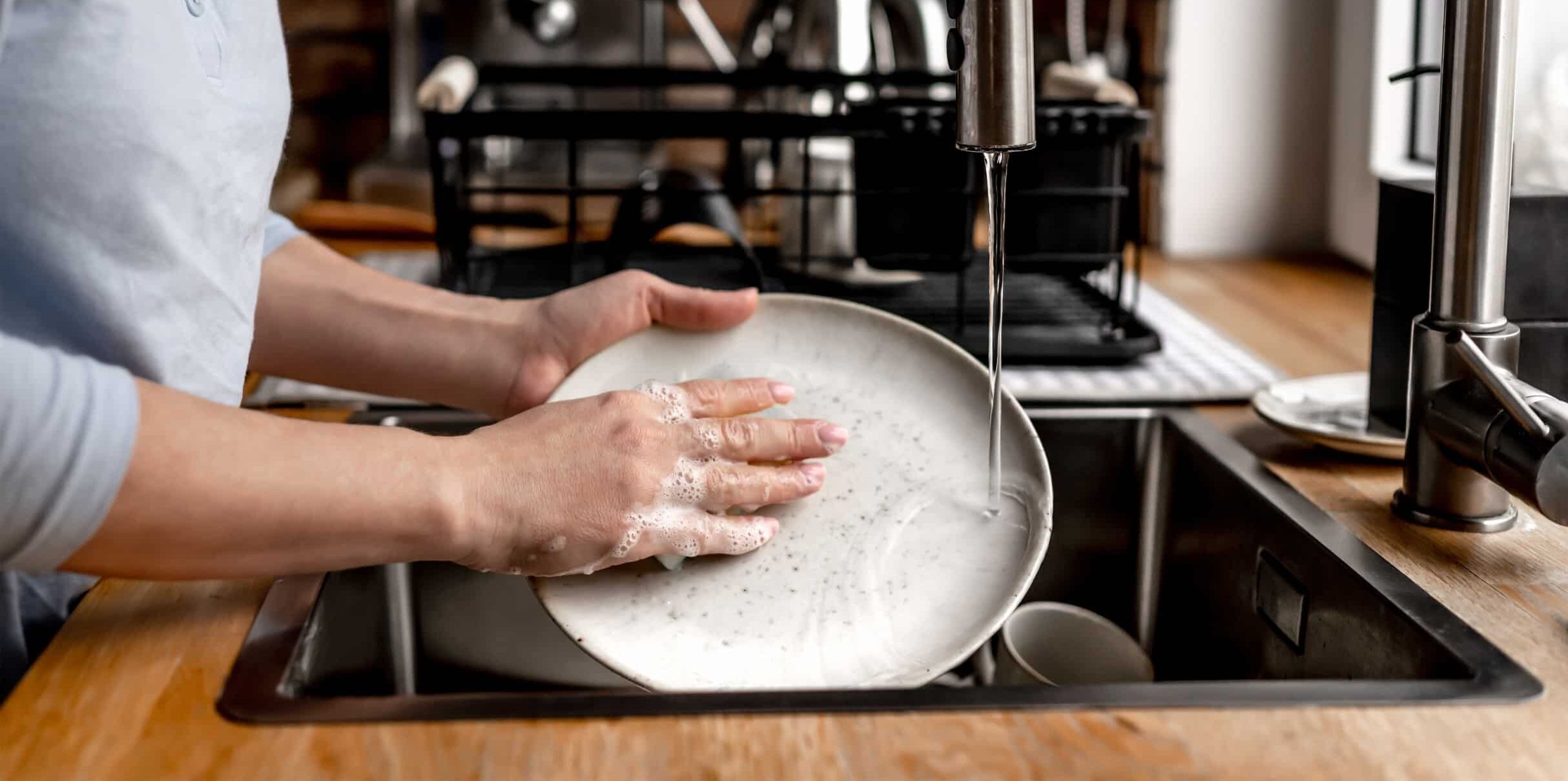 young woman doing dishes in her home